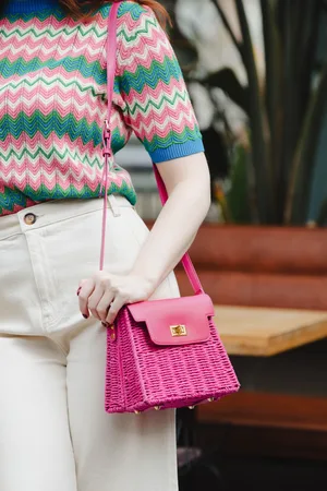 Amici Ollie Rattan Crossbody tas in felroze